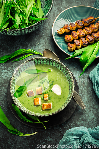 Image of Bear leek soup or ramson soup with crouton, sour cream and turkey skewer