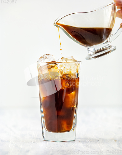 Image of coffee pouring into glass of ice