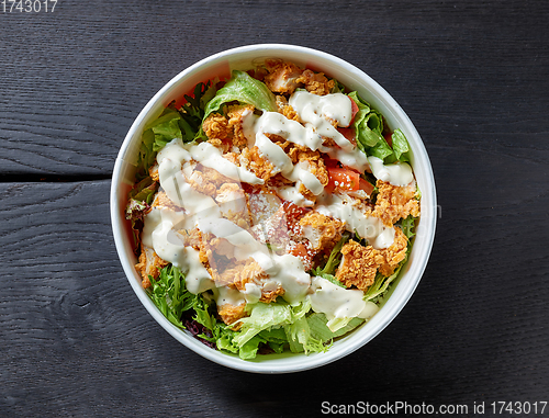 Image of caesar salad on black wooden table