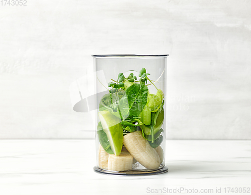 Image of banana and various green vegetables in blender container