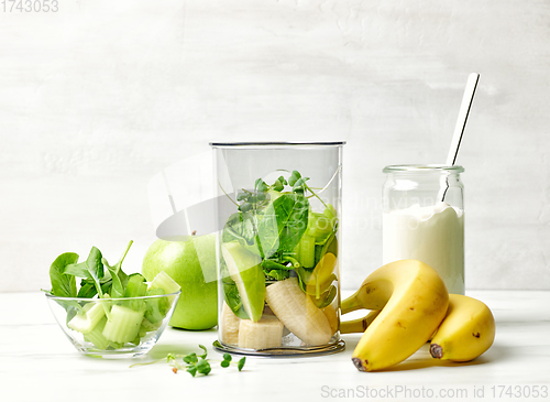 Image of banana and various green vegetables in blender container