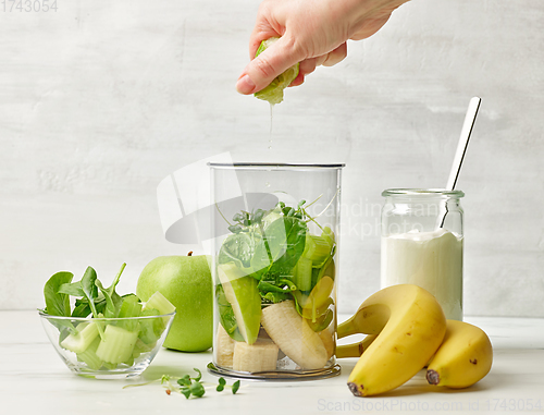 Image of banana and various green vegetables in blender container