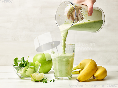 Image of fresh green smoothie pouring into glass