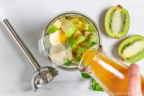 Image of fresh juice pouring into blender container