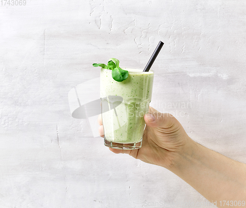 Image of man's hand holds a smoothie glass