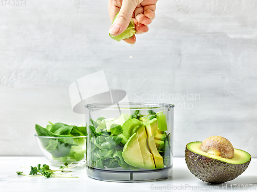 Image of cook squeezing lime into blender container