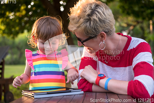 Image of mom and her little daughter using tablet computer