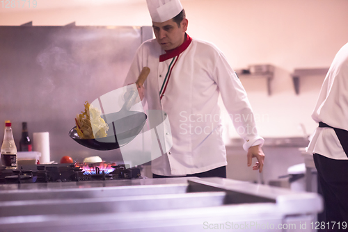 Image of chef flipping vegetables in wok