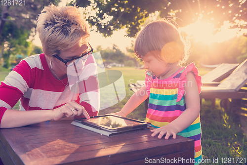 Image of mom and her little daughter using tablet computer