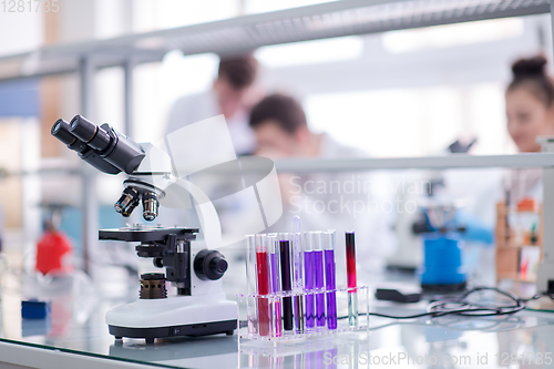 Image of Microscope on the workplace near test tubes