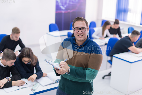 Image of male student with others writing notes