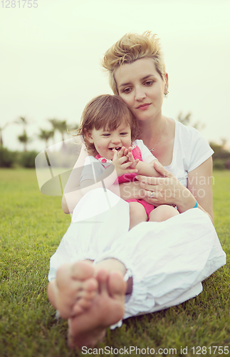 Image of mother and little daughter playing at backyard