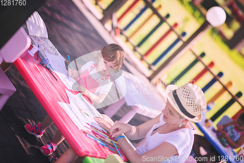 Image of mom and little daughter drawing a colorful pictures