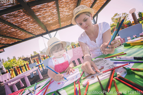 Image of mom and little daughter drawing a colorful pictures