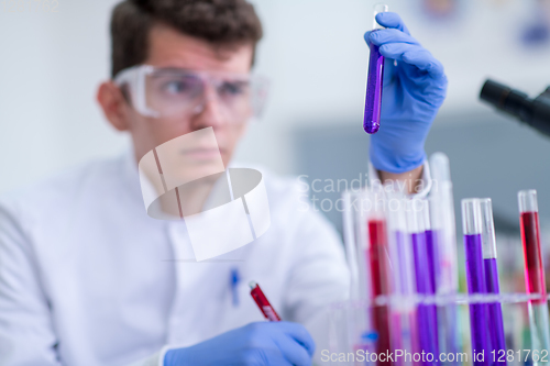 Image of student with protective glasses making chemistry experiment