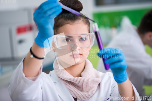 Image of female student with protective glasses making chemistry experime