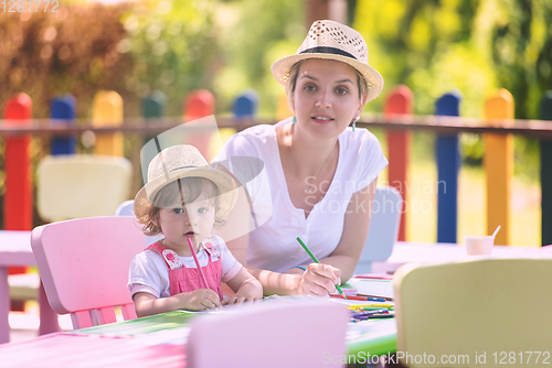 Image of mom and little daughter drawing a colorful pictures