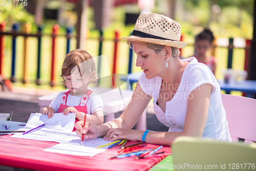 Image of mom and little daughter drawing a colorful pictures