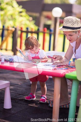 Image of mom and little daughter drawing a colorful pictures