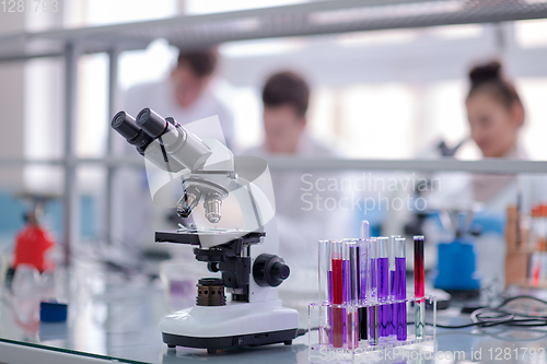 Image of Microscope on the workplace near test tubes