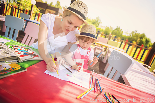 Image of mom and little daughter drawing a colorful pictures