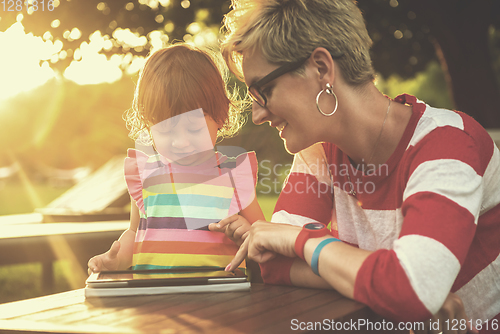 Image of mom and her little daughter using tablet computer