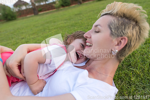 Image of mother and little daughter playing at backyard