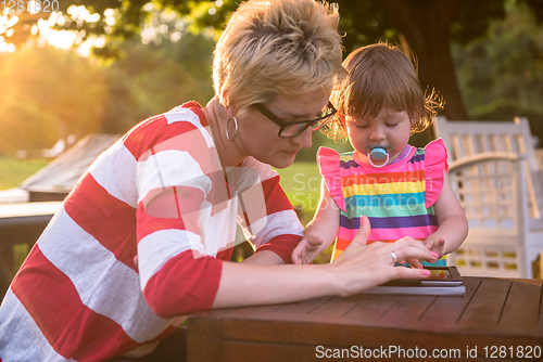 Image of mom and her little daughter using tablet computer