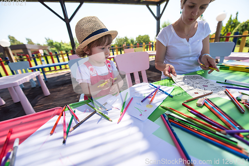 Image of mom and little daughter drawing a colorful pictures