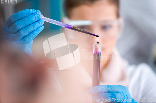 Image of female student with protective glasses making chemistry experime