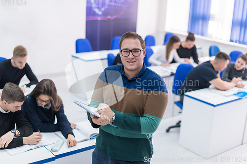 Image of male student with others writing notes