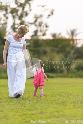 Image of mother and little daughter playing at backyard