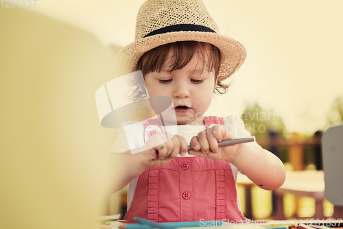 Image of little girl drawing a colorful pictures