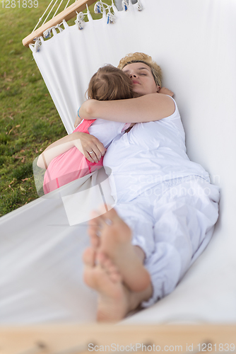 Image of mother and a little daughter relaxing in a hammock