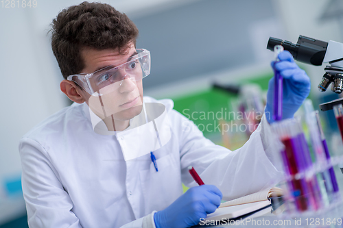 Image of student with protective glasses making chemistry experiment