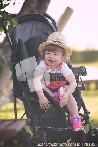 Image of baby girl sitting in the baby stroller