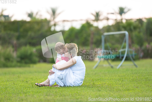 Image of mother and little daughter playing at backyard