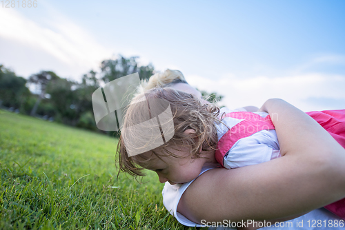 Image of mother and little daughter playing at backyard