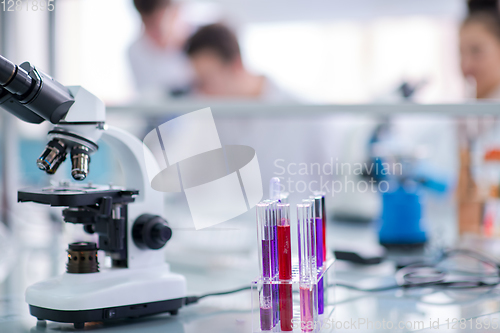 Image of Microscope on the workplace near test tubes