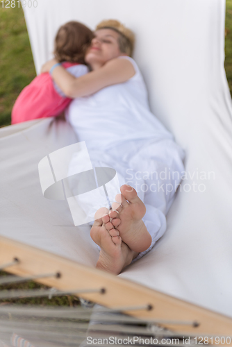 Image of mother and a little daughter relaxing in a hammock