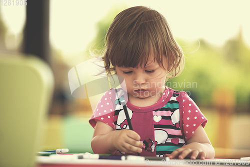 Image of little girl drawing a colorful pictures