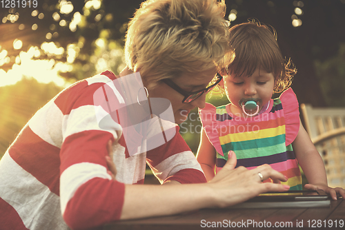 Image of mom and her little daughter using tablet computer