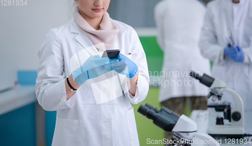 Image of woman scientist using smartphone