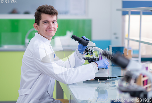 Image of student scientist looking through a microscope