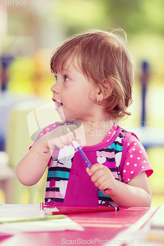 Image of little girl drawing a colorful pictures