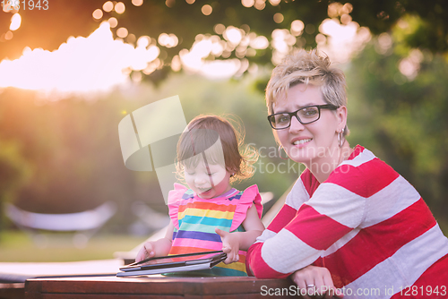 Image of mom and her little daughter using tablet computer