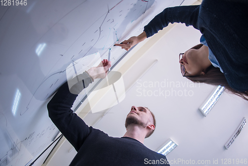 Image of students writing on the white chalkboard