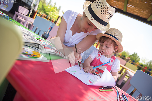 Image of mom and little daughter drawing a colorful pictures