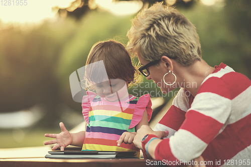 Image of mom and her little daughter using tablet computer