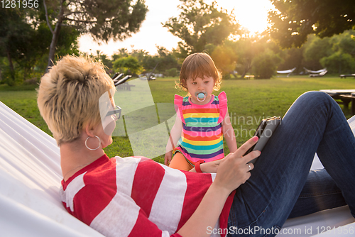 Image of mom and a little daughter relaxing in a hammock